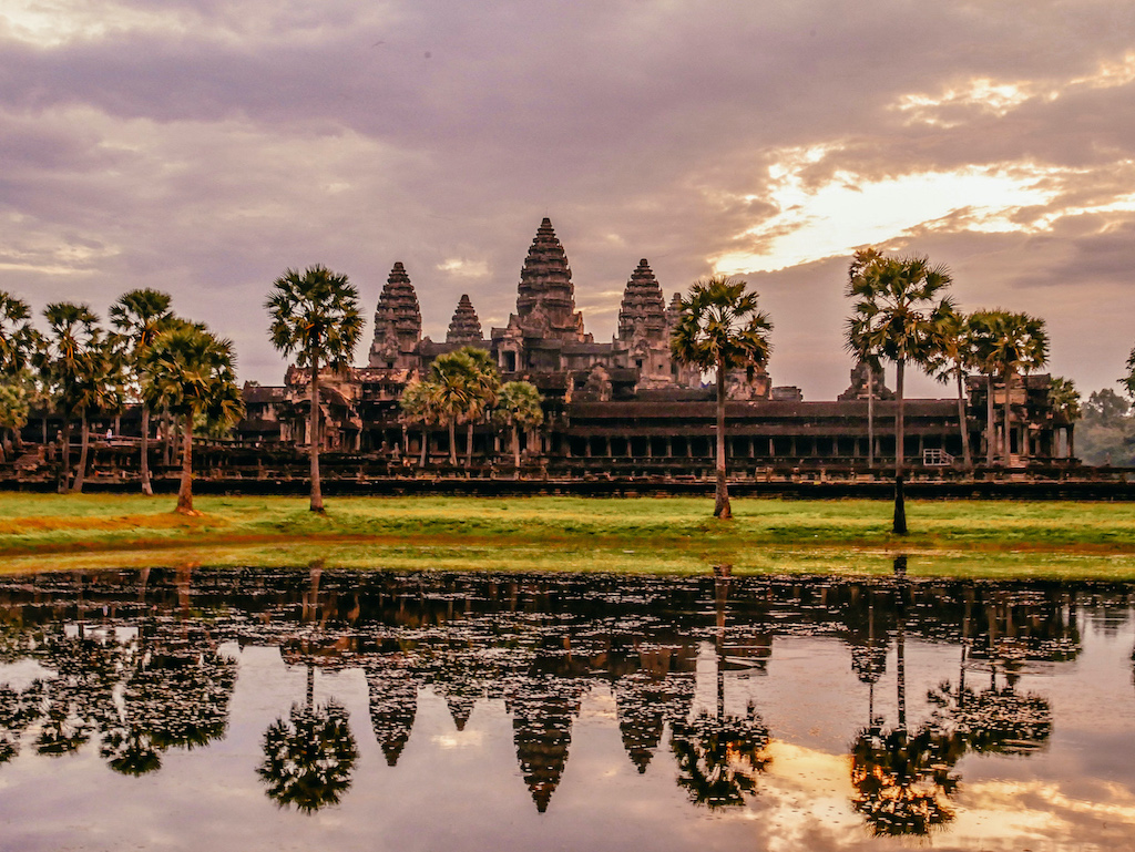 Die Tempelanlage Angkor Wat bei Sonnenaufgang spiegelt sich im See